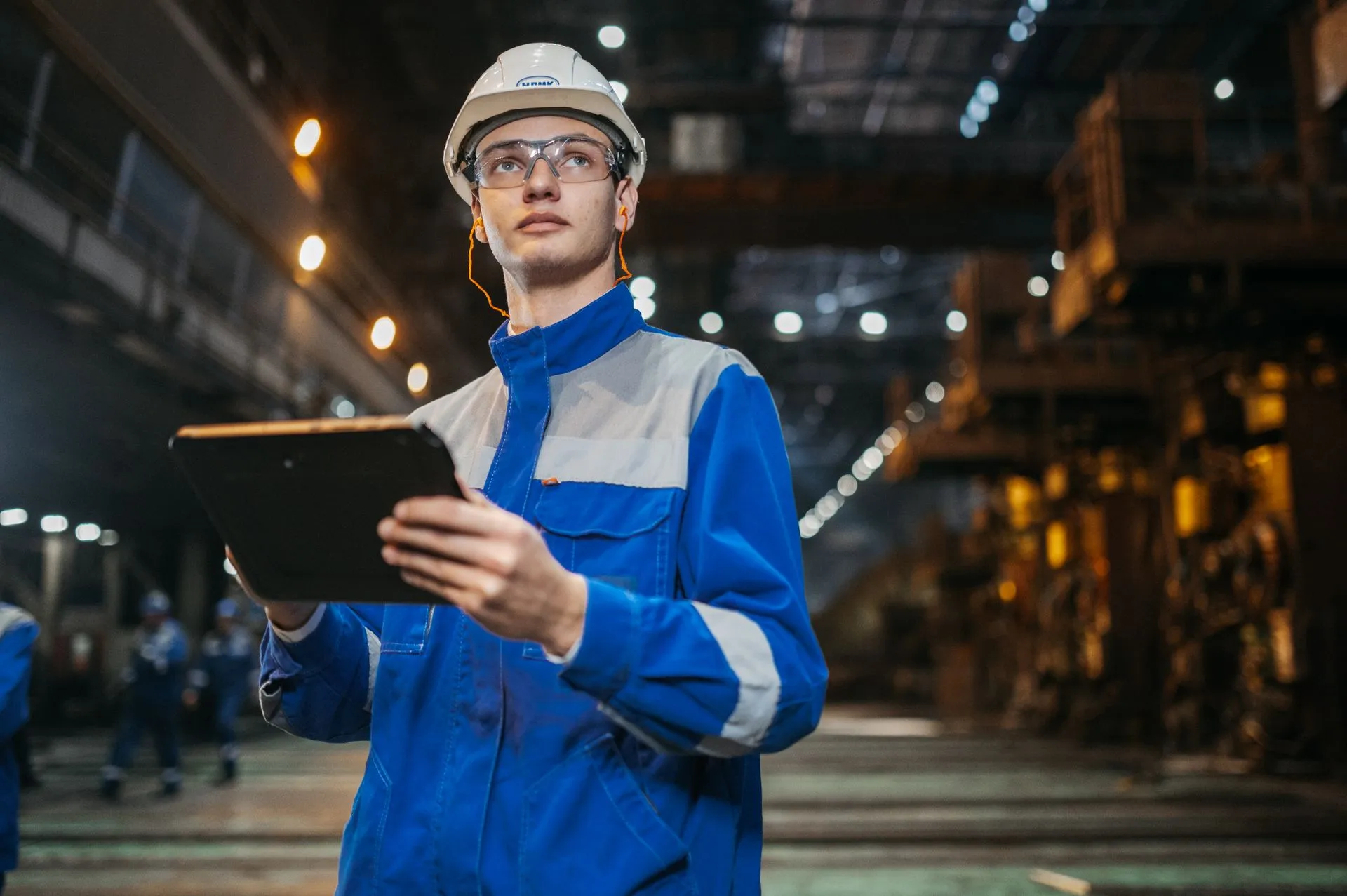 Engineer reviewing plant records on a tablet, representative photography